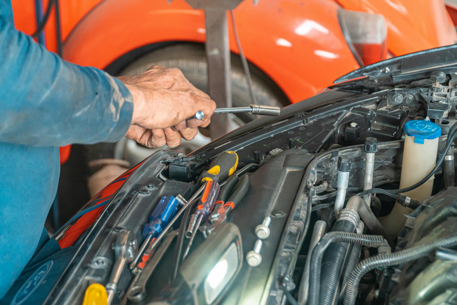 Mechanik wykonuje naprawę instalacji elektrycznej w komorze silnika Mazdy