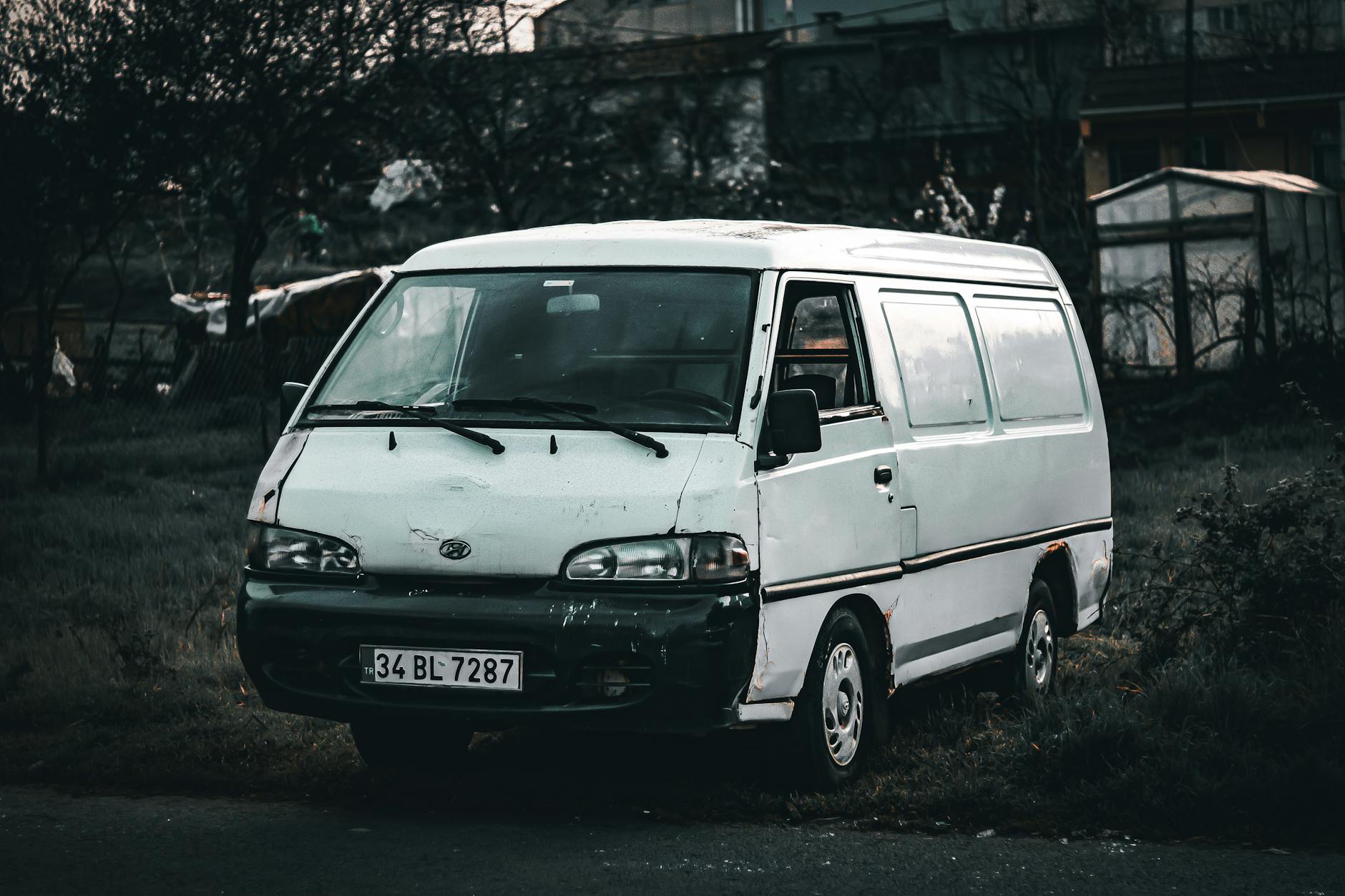Stara minivan Mazda 5 zaparkowana na trawniku w słoneczny dzień