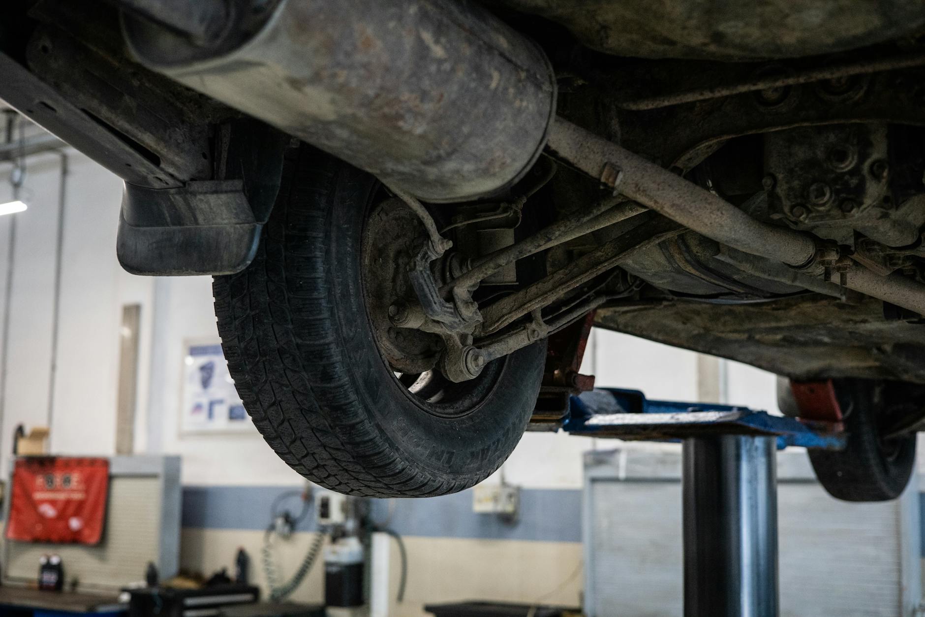 Mechanik ogląda podwozie Mazdy 5 na podnośniku w serwisie